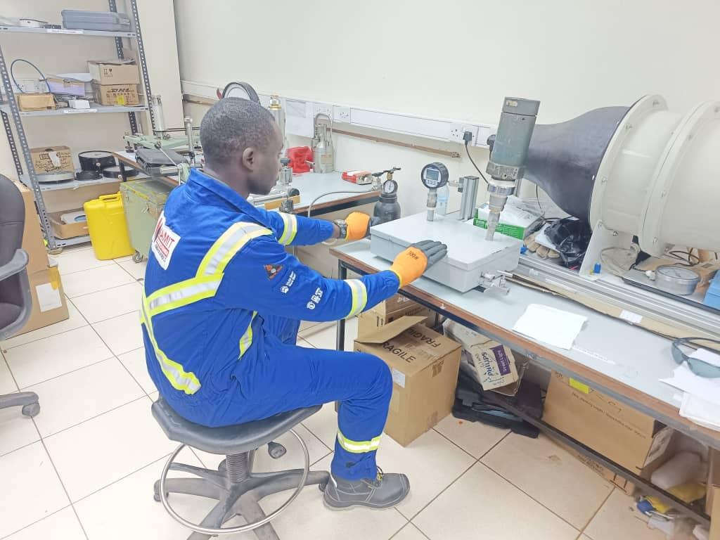 Calibration technician verifying industrial instrumentation at test bench