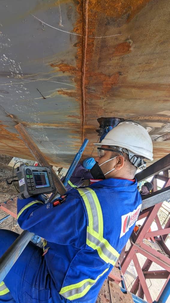 Technician conducting ultrasonic flaw detection on internal hull bulkheads